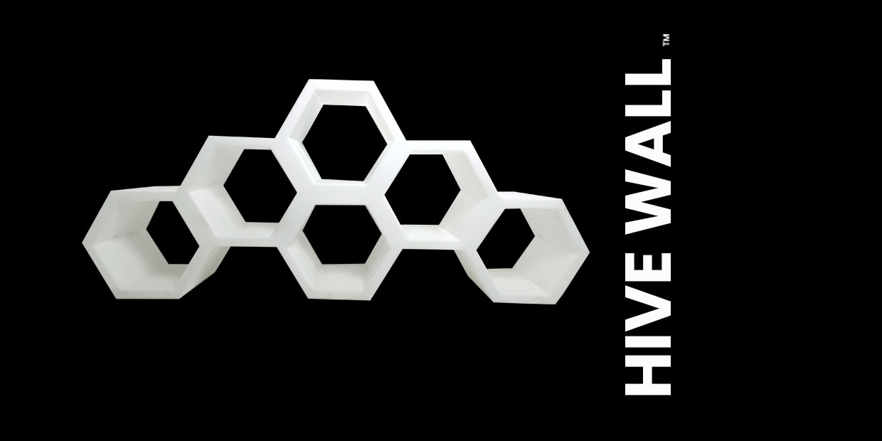 Hexagonal set piece in a honeycomb pattern with the text "HIVE WALL" on the right side, creating a striking modular backdrop.